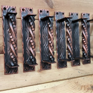 May include: A set of six decorative door handles with a copper finish. The handles are made of metal and have a twisted design. The handles are all the same size and shape.