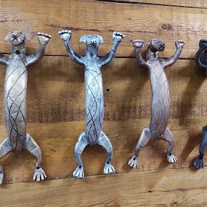 May include: Four decorative door handles shaped like dogs in different finishes: gold, silver, copper, and black.