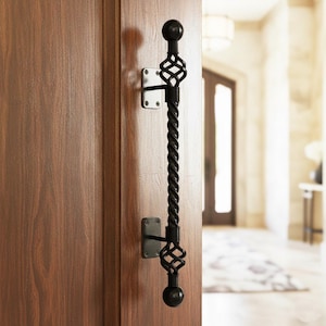 Può includere: Maniglia per porta in ferro battuto nero con centro ritorto e finiture decorative. La maniglia è montata su una porta di legno. La maniglia è lunga circa 46 cm.