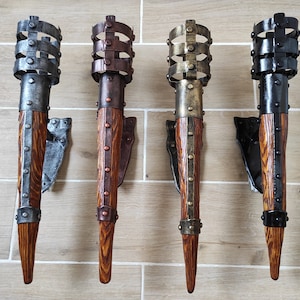 May include: Four wall-mounted torch sconces with a rustic wood and metal design. Each sconce has a different metal finish: silver, copper, gold, and black.