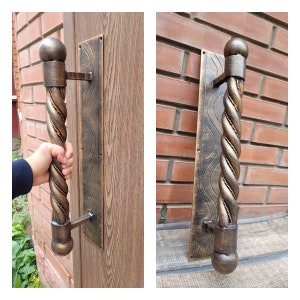 May include: A twisted metal door handle with a decorative plate. The handle is a dark brown color with a gold finish. The plate is a dark brown color with a gold finish and a wavy pattern.