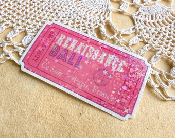 May include: A pink ticket with the words "Renaissance Ball" in a decorative font. The ticket also includes the text "Ce Soir Paris, France" and a graphic of a globe with stars. The ticket is on a beige surface.