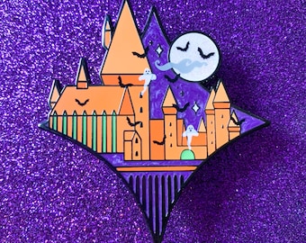 May include: A black and orange enamel pin depicting a castle with a purple and white starry sky background. The castle has multiple towers and windows, and there are bats and ghosts flying around it. A full moon with a bat silhouette is in the upper right corner.