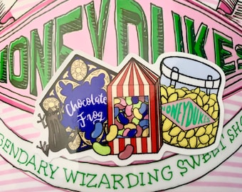 May include: Three Harry Potter themed stickers featuring a chocolate frog, a box of jelly slugs, and a jar of Honeydukes. The stickers are on a pink and white striped background.