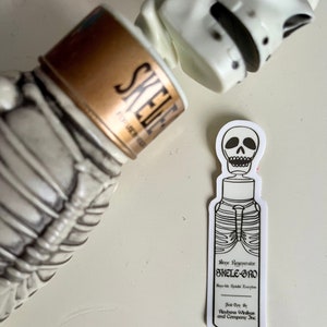 May include: A white sticker with a black and white illustration of a bottle labeled "Bope Regeperator SKELE-GRO Boyu-de Results Koryline" and the text "Sold Only By Reubens Winikus and Company Inc."