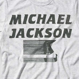 May include: A gray t-shirt with a black graphic print of the text "MICHAEL JACKSON" and a stylized silhouette of Michael Jackson.