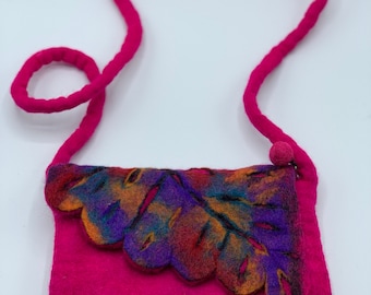 May include: A small pink felt handbag with a colourful felt leaf design. The bag has a long pink felt strap.