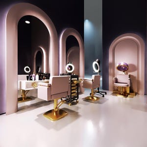 May include: A modern hair salon interior with pink and gold accents. The space features arched doorways, mirrors, and styling stations with chairs. The chairs have gold bases and pink upholstery. There are also hair dryers and styling tools.