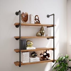 May include: A four-tiered wall-mounted bookshelf with wooden shelves and black metal pipe supports. The shelves display books, sculptures, and decorative vases. The design is industrial-inspired, with a minimalist aesthetic. The shelves are made of wood and the supports are made of black metal.