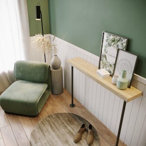 Op de afbeelding: Een modern interieur met een groene fauteuil, een houten console met zwarte metalen poten en ingelijste kunstwerken. Een rond tapijt, een vloerlamp en vazen completeren de minimalistische inrichting. Het kleurenpalet omvat groene, beige en bruine tinten. De tafel is ongeveer 120 cm lang.
