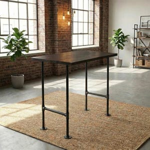 May include: A dark brown rectangular table with black pipe legs. The table is set on a woven brown rug in a room with brick walls and large windows. Two potted plants are visible.