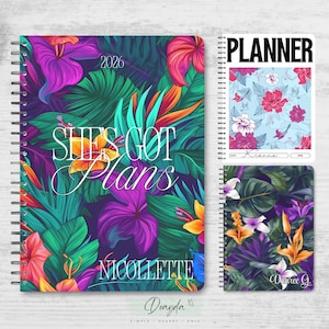 May include: A collection of spiral-bound planners with floral designs. The main planner features a vibrant tropical print with the text "SHE'S GOT Plans" and the name "NICOLETTE". Additional planners showcase floral patterns.