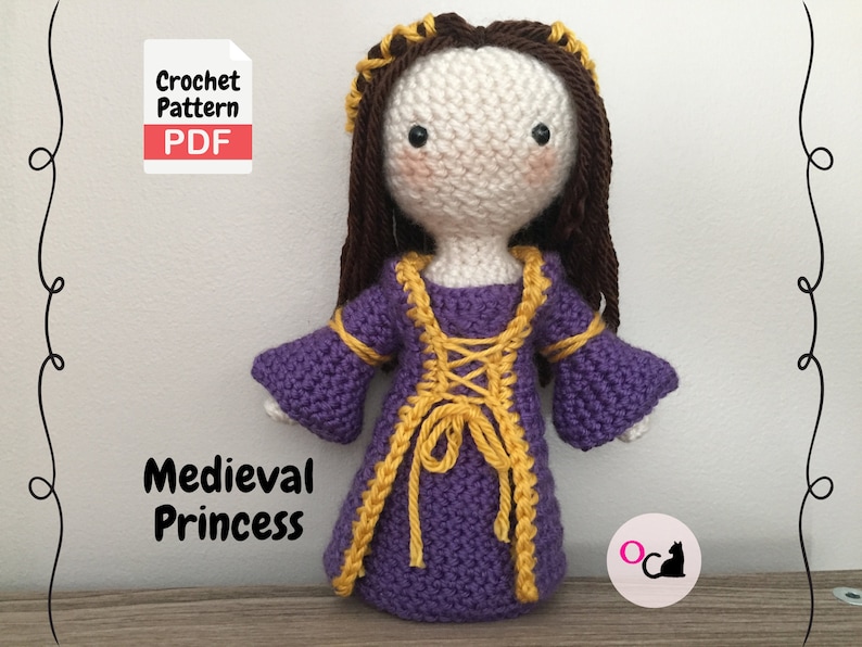 May include: Crochet pattern PDF for a medieval princess doll. The doll is wearing a purple dress with yellow trim and a brown hair crown. The doll is standing on a wooden surface.