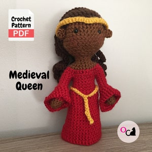 May include: Crochet pattern PDF for a Medieval Queen doll. The doll is brown-skinned and wears a red dress with a yellow belt and crown. The doll is standing on a wooden surface.