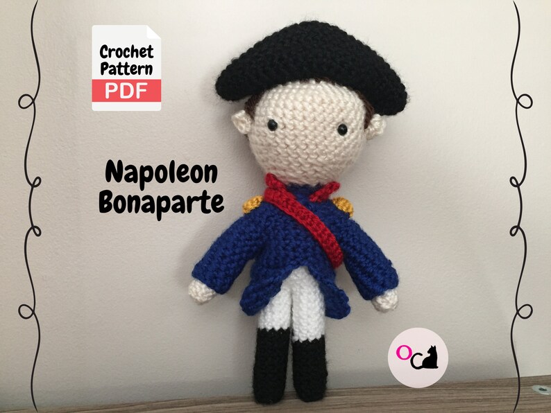 May include: Crochet pattern PDF for a Napoleon Bonaparte amigurumi doll. The doll is wearing a blue jacket with red and yellow accents, a white shirt, and black boots. The doll has a black hat and a white face with black eyes.