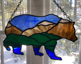 Vidriera de oso grizzly con paisaje