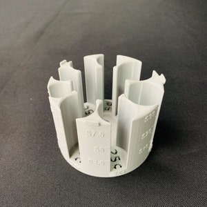 May include: Grey plastic coin holder with slots for different denominations. The holder has markings for £7.50, £5, £2.50, £1, 50p, 25p, 10p, 5p, and 1p.