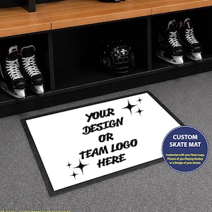 May include: A rectangular white floor mat with a black border featuring the black text "YOUR DESIGN OR TEAM LOGO HERE" and four star icons. A circular blue badge on the right reads "CUSTOM SKATE MAT" with additional descriptive text.