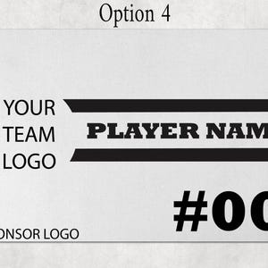 May include: A rectangular white sign featuring black text and graphics. The design includes the text YOUR TEAM LOGO, PLAYER NAME, and SPONSOR LOGO, along with the number #00. Two horizontal black stripes frame the player name area.
