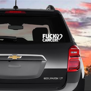 May include: A black car with a white sticker on the rear window that reads "FUCK CANCER" with a pink ribbon symbol.