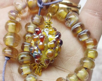 glaskralen handgemaakt van Italiaans glas met een bijpassende hanger in goudgele kleuren By Petra Hergarden