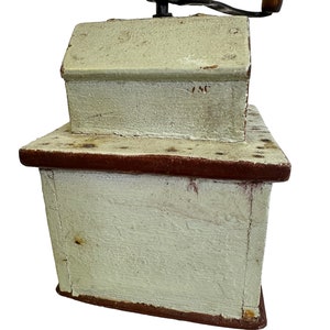 May include: Antique wooden coffee grinder with a hand crank, painted white with red accents and the number "146" on the top.