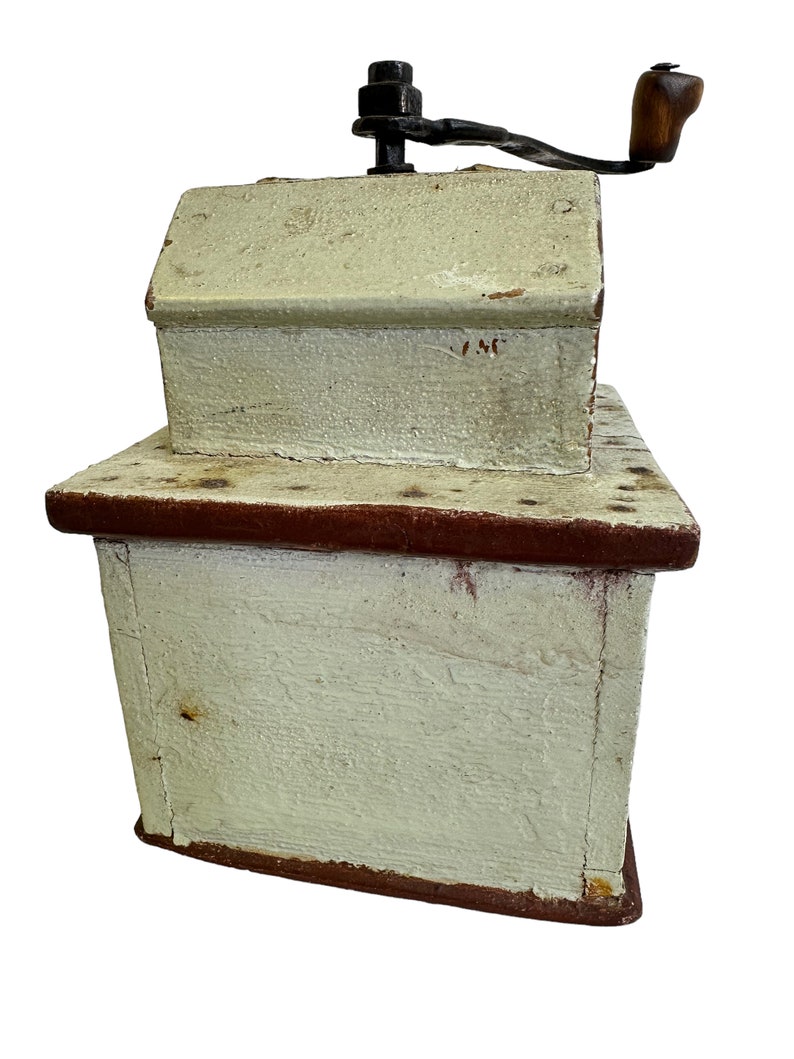 May include: Antique wooden coffee grinder with a hand crank, painted white with red accents and the number "146" on the top.