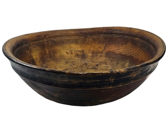 Puede incluir: Un tazón grande de madera con una mancha marrón oscura y un interior marrón claro. El tazón tiene forma ovalada y un borde ligeramente elevado.