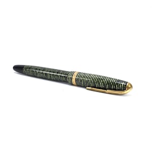 Vintage Parker Vacumatic fountain pen in Emerald Pearl laminated striped celluloid finish, produced circa 1930s–1940s. Features iconic Parker arrow clip, gold-filled trim band, and 14K gold nib. Classic Art Deco design with semi-transparent green and black stacked celluloid barrel. The Vacumatic plunger filling system requires diaphragm replacement and the pen has not been tested. Good vintage condition with light surface wear consistent with age.