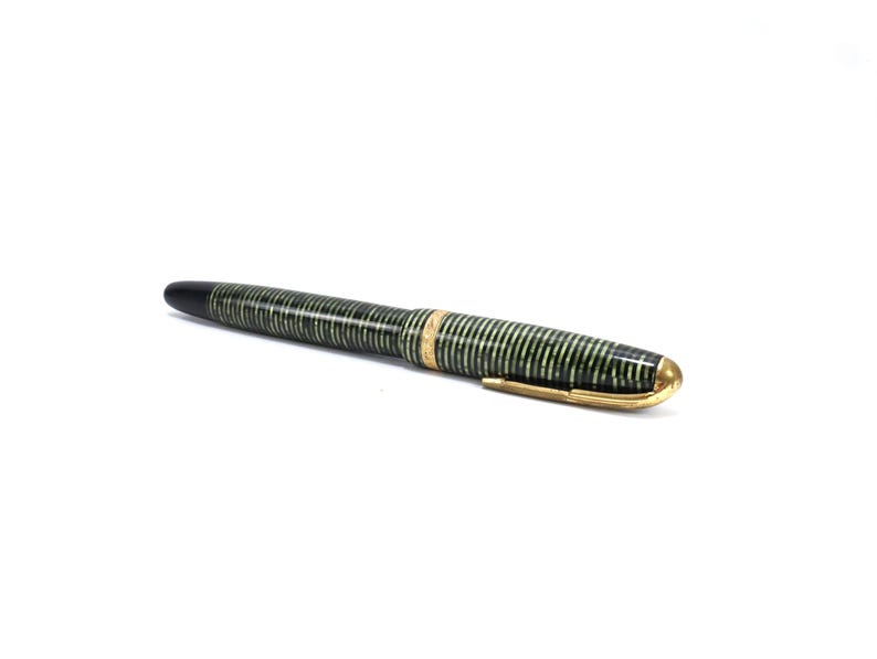 Vintage Parker Vacumatic fountain pen in Emerald Pearl laminated striped celluloid finish, produced circa 1930s–1940s. Features iconic Parker arrow clip, gold-filled trim band, and 14K gold nib. Classic Art Deco design with semi-transparent green and black stacked celluloid barrel. The Vacumatic plunger filling system requires diaphragm replacement and the pen has not been tested. Good vintage condition with light surface wear consistent with age.