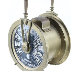 Può includere: Telegrafo del motore della nave in ottone con un quadrante nero e marcature bianche. Il telegrafo è etichettato "Chadurns Liverpool & London" e ha due leve. Il quadrante indica "Stop", "Slow", "Half", "Full", "Astern", "Full", "Half", "Slow", "Dead Slow", "Finished with Engine".