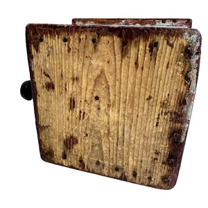 May include: A wooden box with a hinged lid and a small handle. The box is made of rough-hewn wood and has a rustic appearance. The box is painted a dark brown color and has a few nails visible.