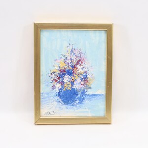 Peut inclure: Peinture encadrée originale d'une composition florale. L'œuvre présente un bouquet de fleurs colorées dans un vase bleu sur un fond bleu clair. La peinture est dans un cadre doré.