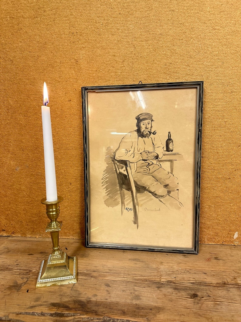 May include: A framed black and white drawing of a man sitting in a chair, holding a pipe and a bottle. The man is wearing a cap and has a beard. The drawing is signed "4571" and "Ormond".