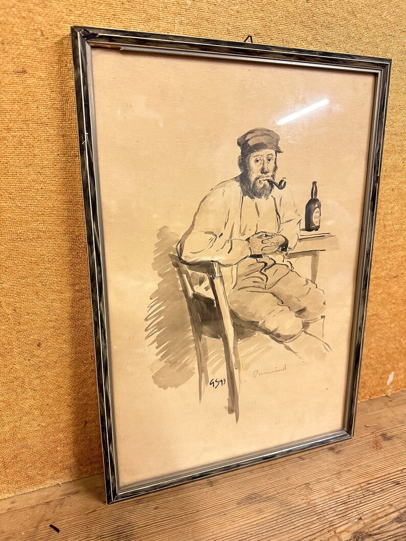 May include: A framed black and white ink drawing of a man sitting in a chair with a pipe in his mouth and a bottle of beer on a table. The drawing is signed "Dementi" and dated "4511".