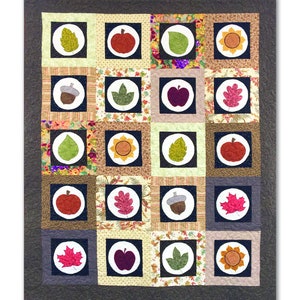 May include: A quilt pattern featuring a harvest moon theme with various autumnal motifs, including leaves, apples, acorns, and sunflowers. The quilt is made up of a grid of 20 squares, each containing a different motif. The quilt is surrounded by a dark gray border. The text "Harvest Moon Quilt" is at the top of the image. The text "By Emma Ablett" and "www.quilterstradingpost.com" are at the bottom of the image.