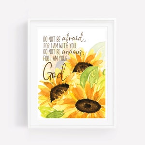 Op de afbeelding: Een aquarel van zonnebloemen met de tekst "Wees niet bang, want Ik ben met je. Wees niet ontmoedigd, want Ik ben jouw God" en de bijbelverwijzing "PSALM 46:10".