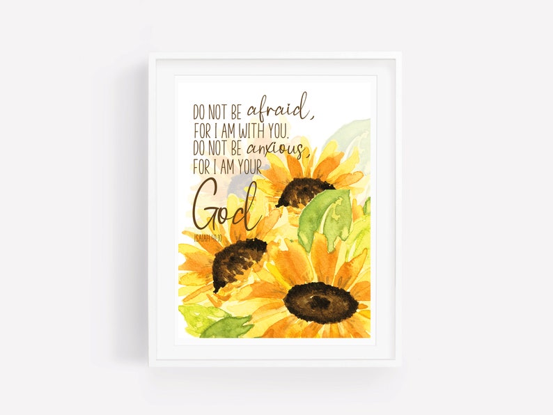 Op de afbeelding: Een aquarel van zonnebloemen met de tekst "Wees niet bang, want Ik ben met je. Wees niet ontmoedigd, want Ik ben jouw God" en de bijbelverwijzing "PSALM 46:10".