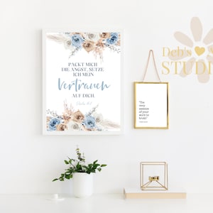 Pode incluir: Uma impress&atilde;o emoldurada branca com um design floral e o texto "PACKT MICH DIE ANGST, SETZE ICH MEIN VERTRAUEN AUF DICH.  PSALM 56:3" em letras azuis e marrons. A impress&atilde;o est&aacute; pendurada em uma parede branca com uma impress&atilde;o emoldurada branca menor pendurada abaixo. A impress&atilde;o menor tem o texto "The very essence of your word is truth." em letras pretas.