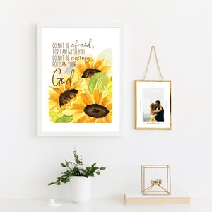 Op de afbeelding: Een wit ingelijst afdruk met een aquarel van zonnebloemen en de tekst "DO NOT BE afraid, FOR I AM WITH YOU. DO NOT BE anxious FOR I AM YOUR God."