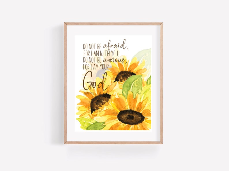 Op de afbeelding: Een aquarel schilderij van zonnebloemen met de tekst "DO NOT BE afraid, FOR I AM WITH YOU. DO NOT BE anxious, FOR I AM YOUR God" gedrukt op een witte achtergrond.