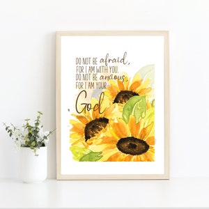 Op de afbeelding: Een aquarel van zonnebloemen met de tekst "DO NOT BE afraid, FOR I AM WITH YOU. DO NOT BE anxious, FOR I AM YOUR God" gedrukt op een witte achtergrond.