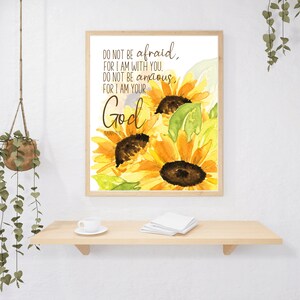 Op de afbeelding: Een aquarel van zonnebloemen met de tekst "DO NOT BE afraid, FOR I AM WITH YOU, DO NOT BE anxious, FOR I AM YOUR God" in bruine tekst.