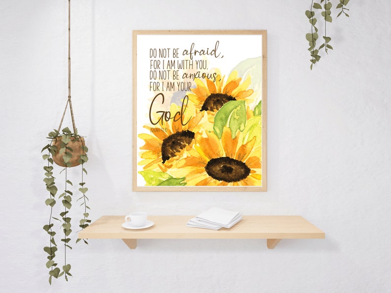 Op de afbeelding: Een aquarel van zonnebloemen met de tekst "DO NOT BE afraid, FOR I AM WITH YOU, DO NOT BE anxious, FOR I AM YOUR God" in bruine tekst.