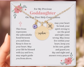 May include: A gold necklace with a pendant that says "Sophia" and a purple gem. The card reads "For My Precious Goddaughter" and "On Your First Holy Communion". The text also includes a cross and a prayer.