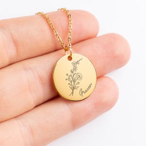 May include: Gold necklace with a round pendant featuring a delicate floral design and the name "Gracen" engraved on it.