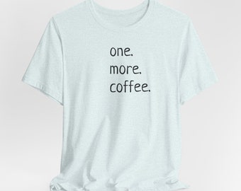 May include: Light blue t-shirt with the text "one. more. coffee." printed in black.