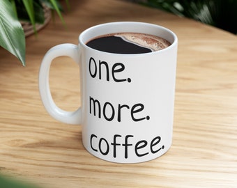 May include: White ceramic coffee mug with black text that reads "one. more. coffee."