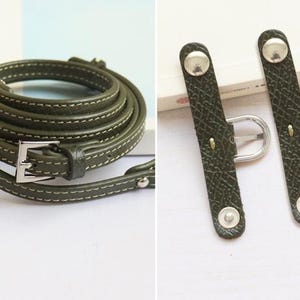 May include: A green leather strap with a silver buckle and two matching green leather strap adjusters with silver buckles.
