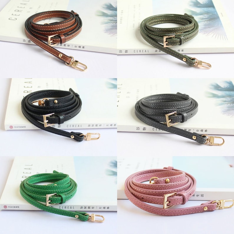May include: Set of five leather straps with gold-tone hardware. The straps are in different colours: brown, green, black, green, and pink. Each strap has a buckle and a swivel hook.